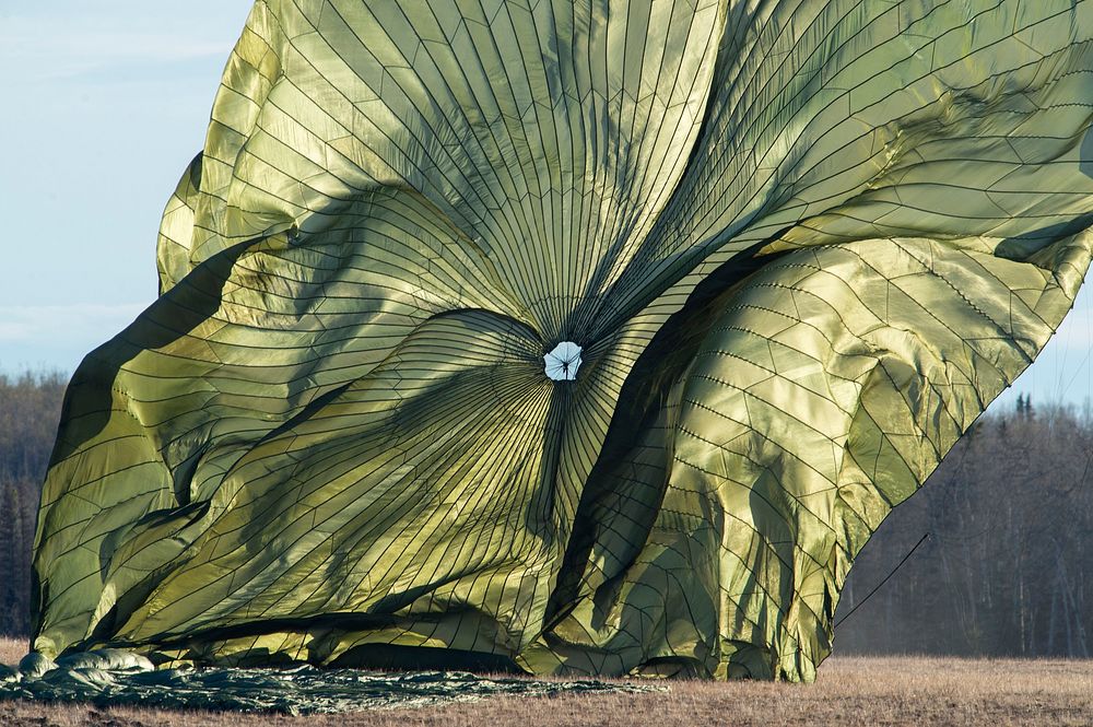 A heavy pallet parachute collapses after being deployed from a U.S. Air Force C-17-Globemaster III operated by the 517th…