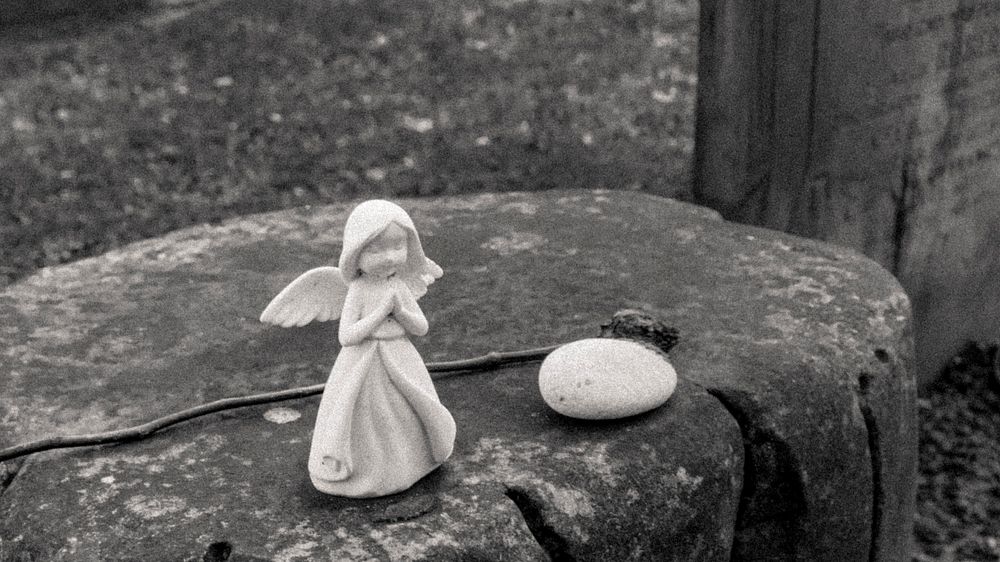 Little angel sculture on a rock. Original public domain image from Flickr