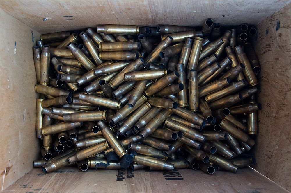 Spent 7.62 mm ammunition casings are collected by Army paratroopers. Original public domain image from Flickr