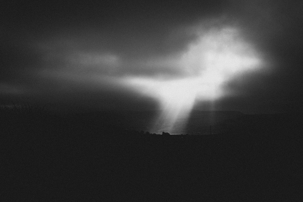 Sunlight through cloudy sky, monotone. Original public domain image from Flickr