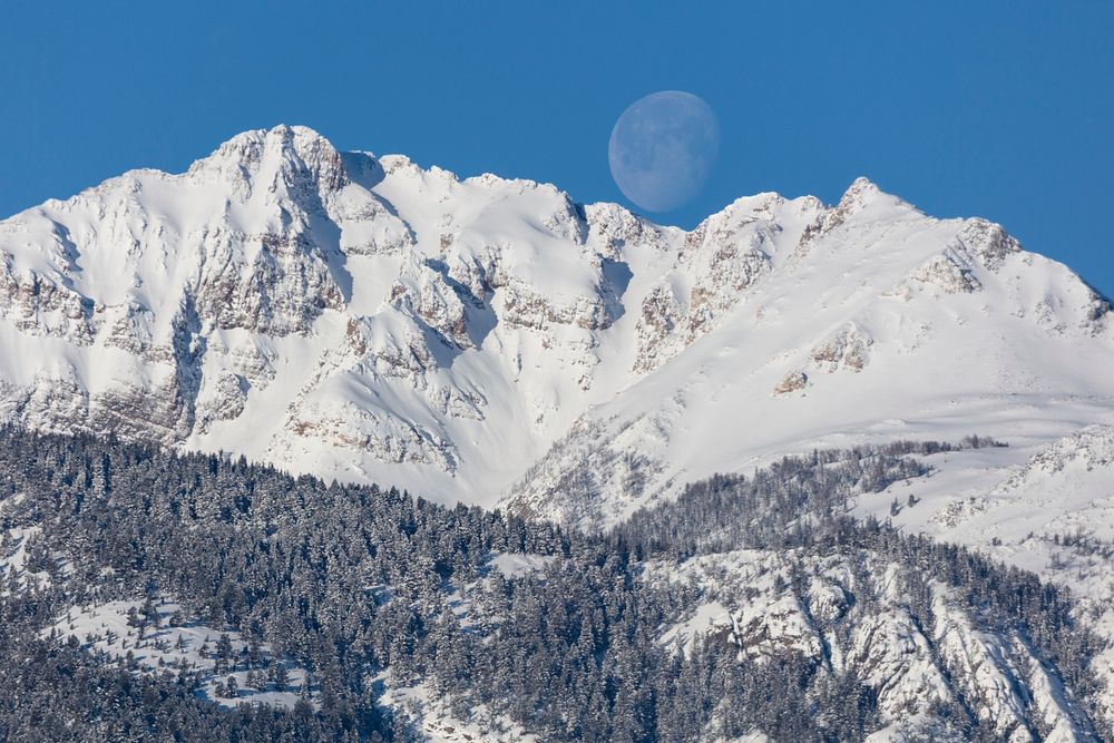 The moon framed by the saddle of Electric Peak, USA. Original public domain image from Flickr
