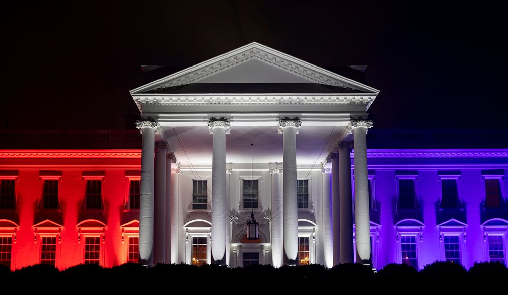 The White House North Portico is lit in red-white and blue lights Saturday evening, July 4, during the Salute to America…