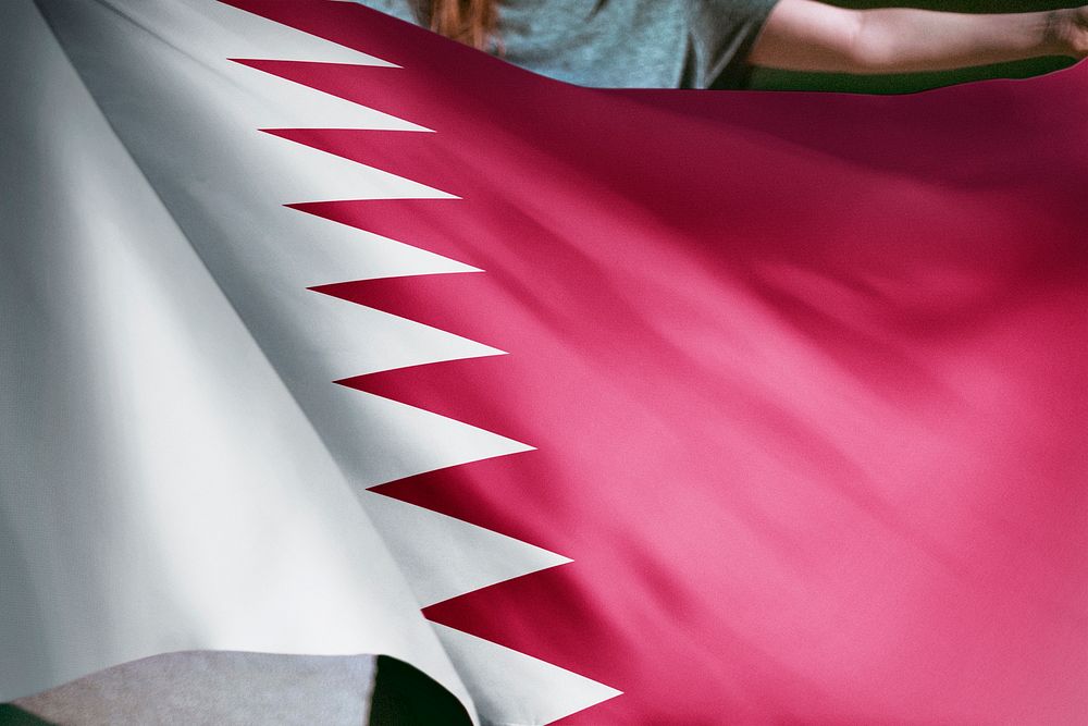 Person holding Qatar flag background, national symbol
