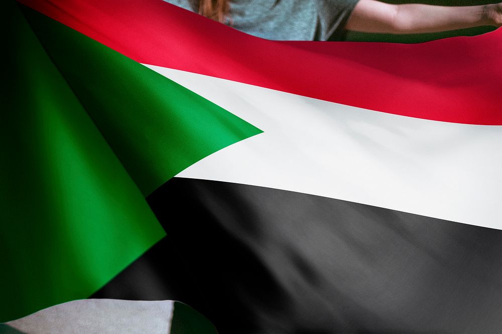 Person holding Sudan flag background, national symbol