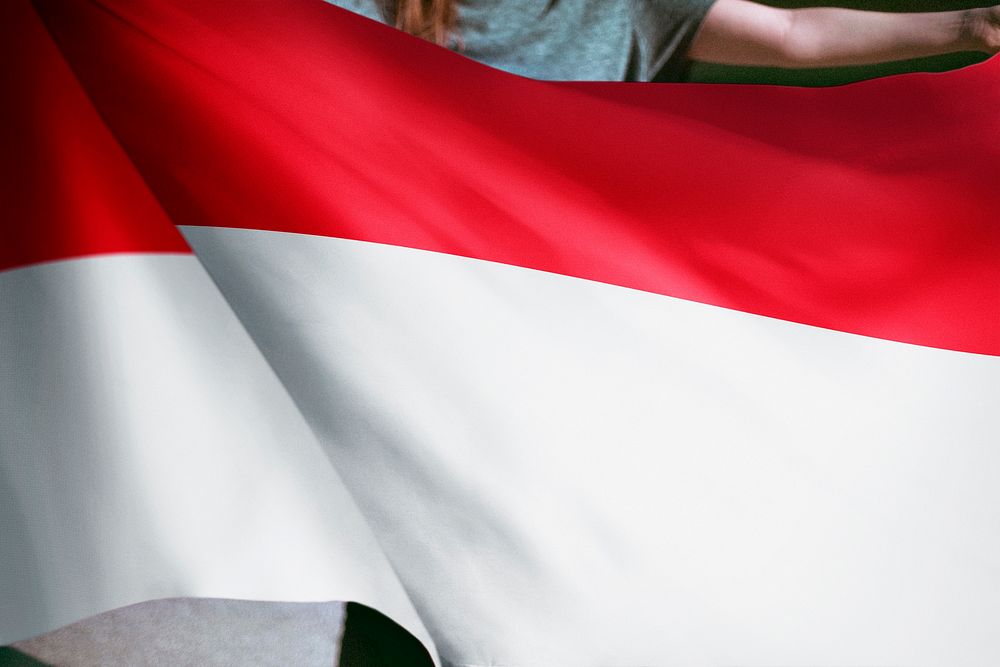 Person holding Indonesian flag background, national symbol