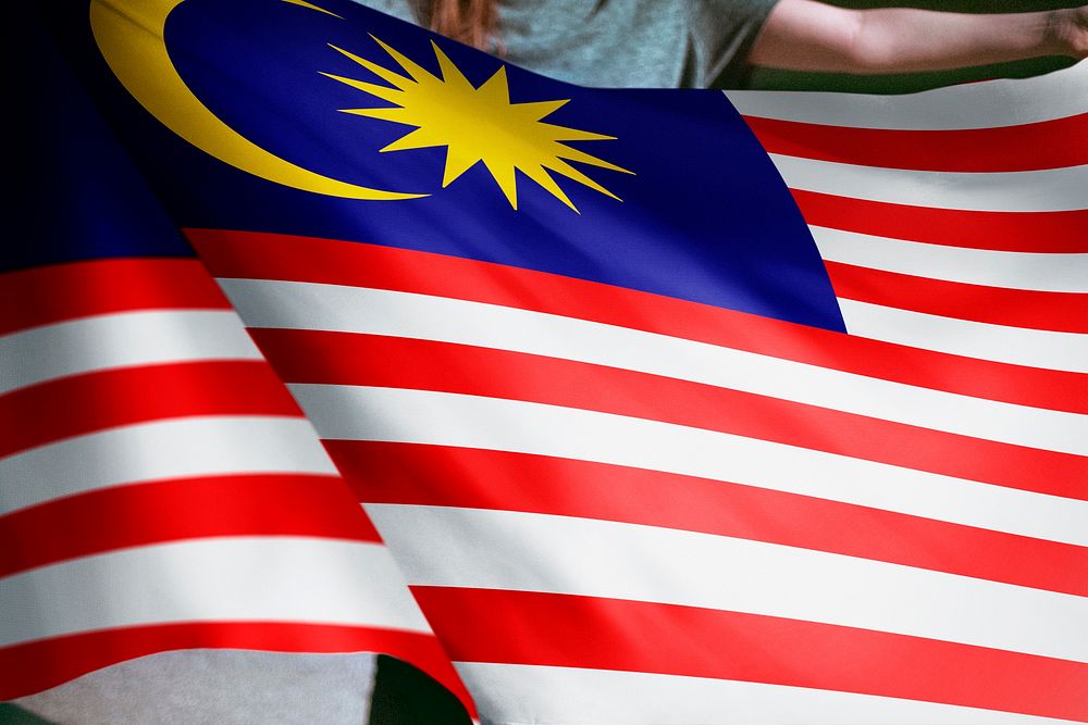 Person holding Malaysian flag background, national symbol