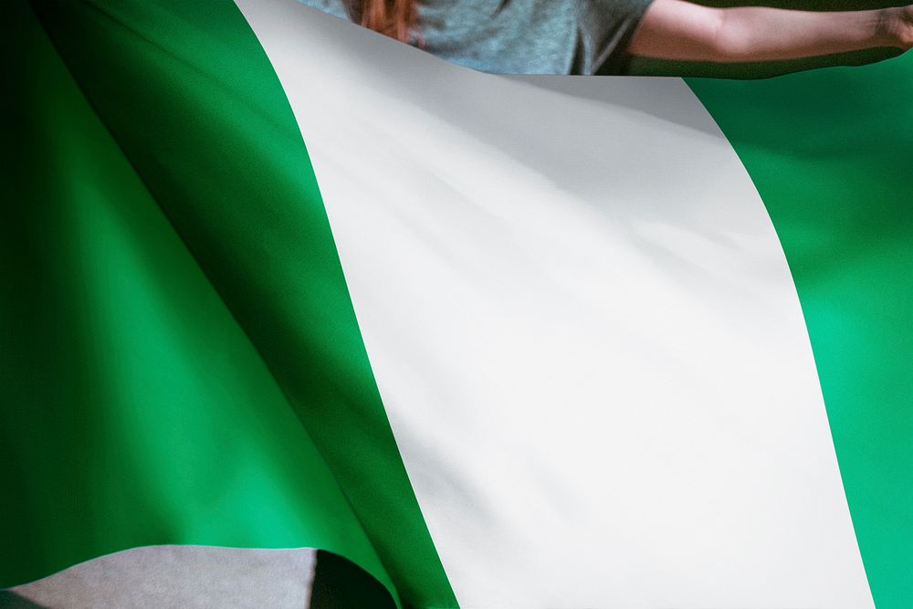 Person holding Nigerian flag background, national symbol