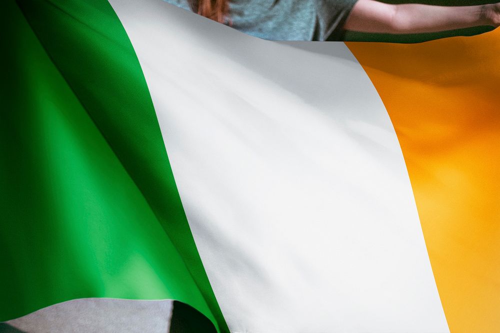 Person holding Irish flag background, national symbol