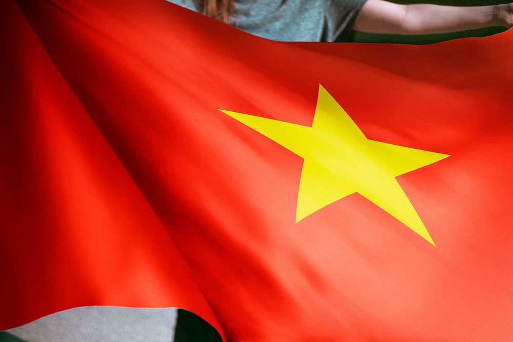 Person holding Vietnamese flag background, national symbol