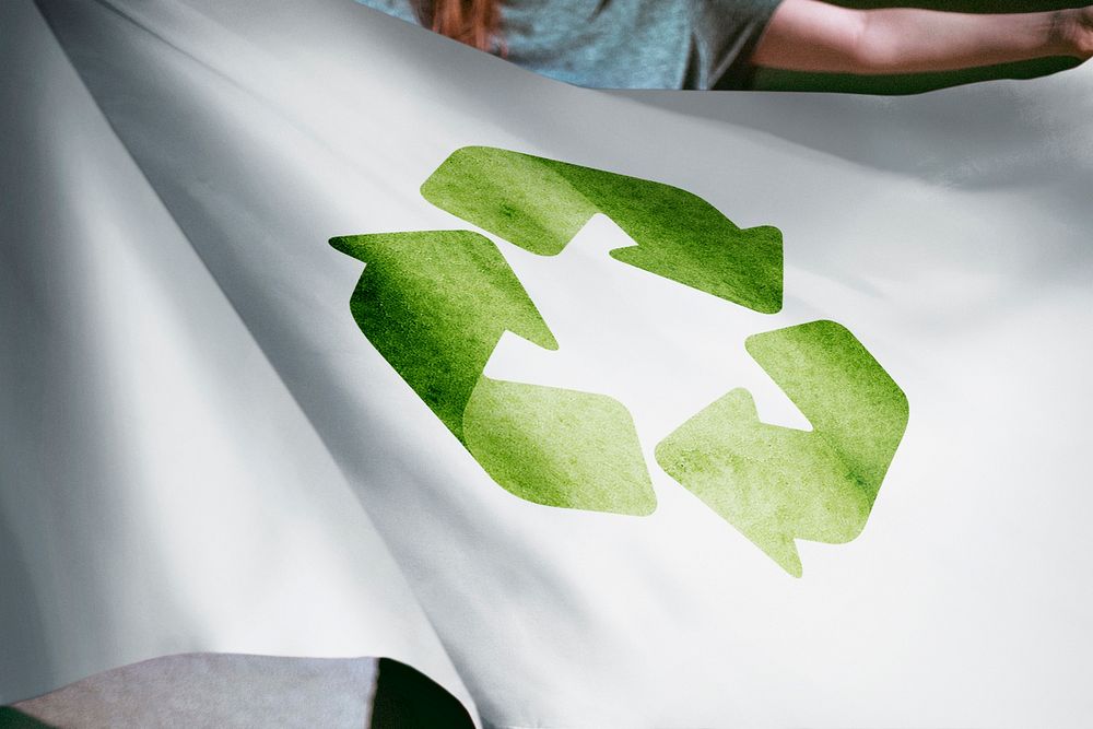 Person holding recycle flag, environmental friendly background