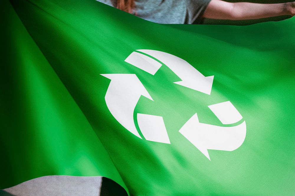 Person holding green recycle flag, environmental friendly background