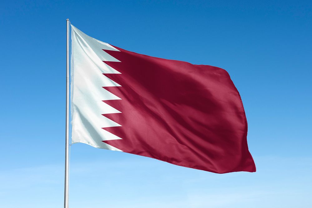 Waving Qatar flag, national symbol, blue sky