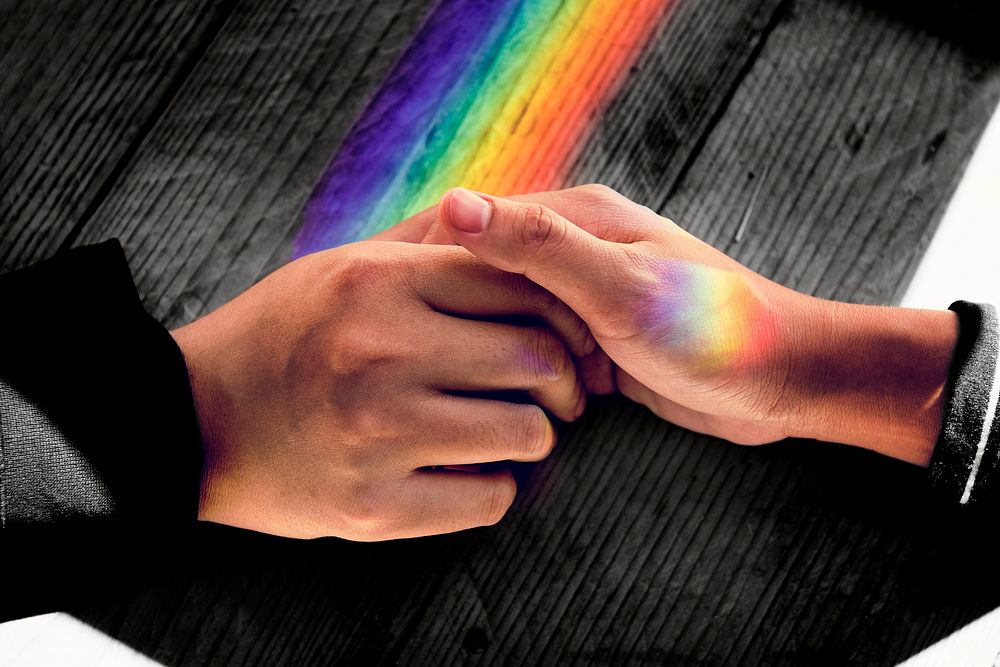 Couple holding hands, LGBTQ rainbow aesthetic light