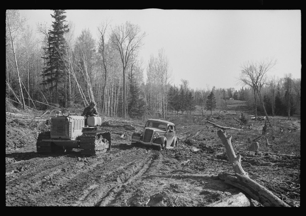 FSA (Farm Security Administration) photographer being pulled out of mud by tractor, near Littlefork, Minnesota. Sourced from…
