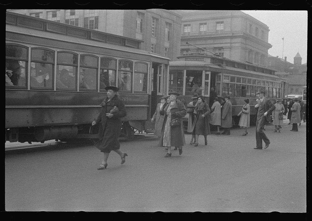 Washington, D.C. A street scene in front of the United States Bureau of Engraving, showing workers boarding street cars on…