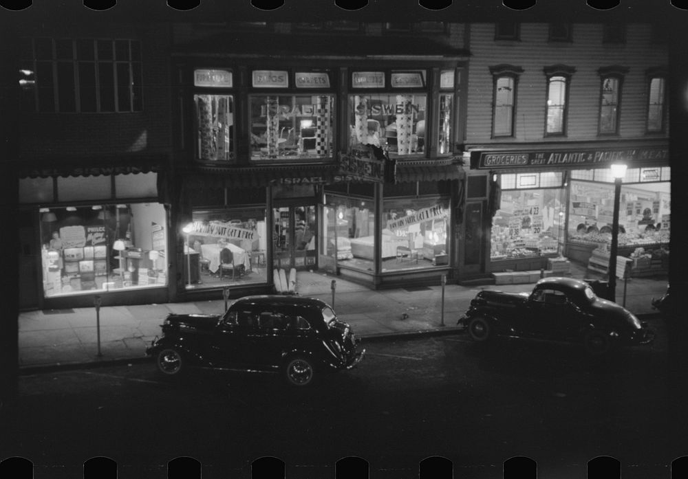 Shenandoah(?), Pennsylvania. Display windows of a furniture store and an Atlantic and Pacific grocery, at night. Sourced…