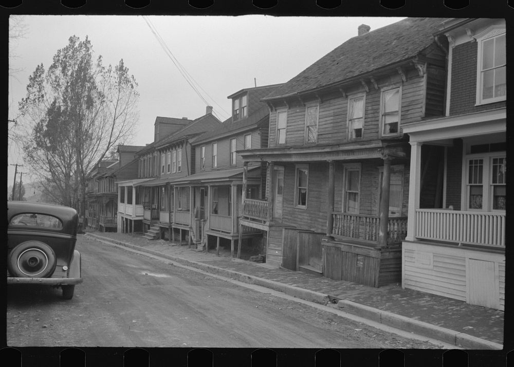 Shenandoah(?), Pennsylvania. Homes of a mining town on an unpaved street, built out to the edge of narrow brick sidewalks.…