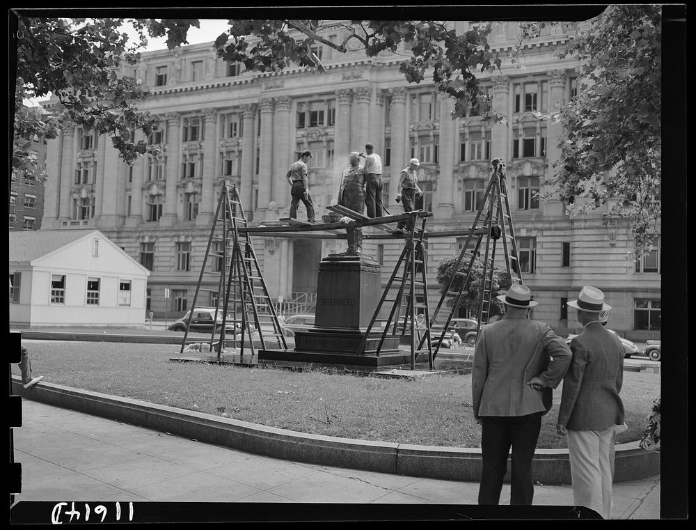 Washington, D.C. Workmen from a monument cleaning company cleaning Shepherd's statue at 14th and E Street, N.W.. Sourced…