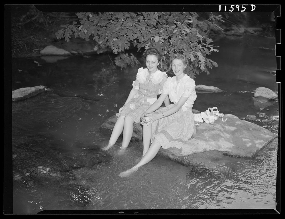 Washington, D.C. Girls on a hot day holding their feet in water in Rock Creek Park. Sourced from the Library of Congress.