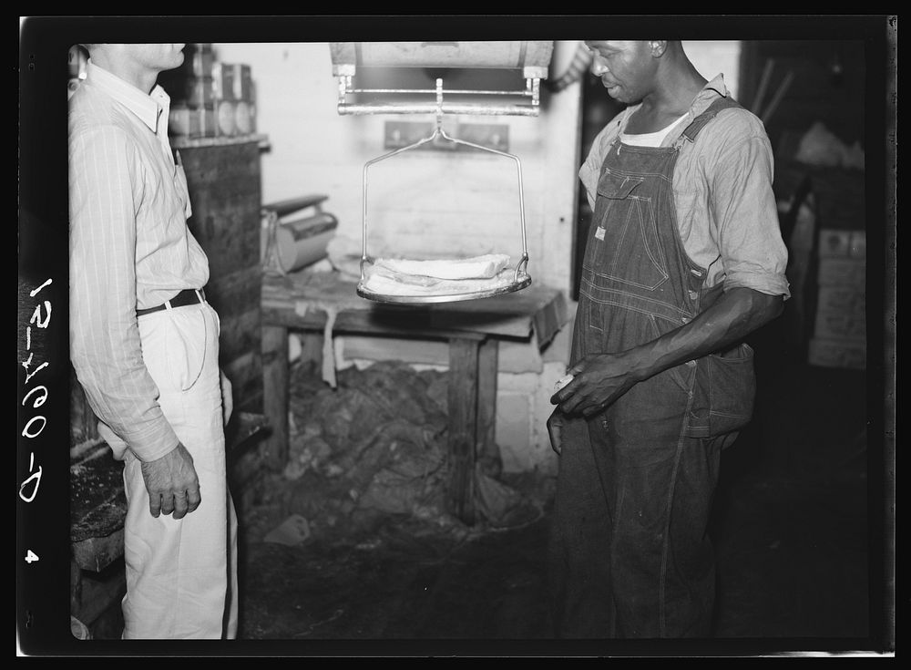 Weighing fatback in country grocery store. Florence County, South Carolina. Sourced from the Library of Congress.