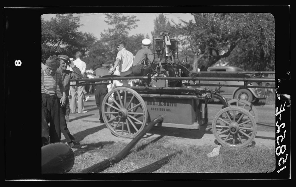 Firemen's muster. Boothbay center, Maine. Typical handpump manned by twenty-four men, twelve along each of the handle bars.…