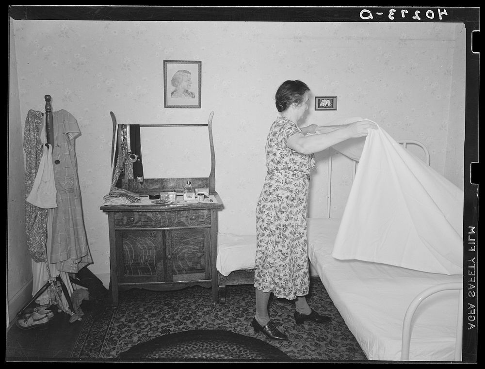 Lancaster County, Pennsylvania. Mrs. Royer making Martha Royer's bed on the Enos Royer farm. Sourced from the Library of…