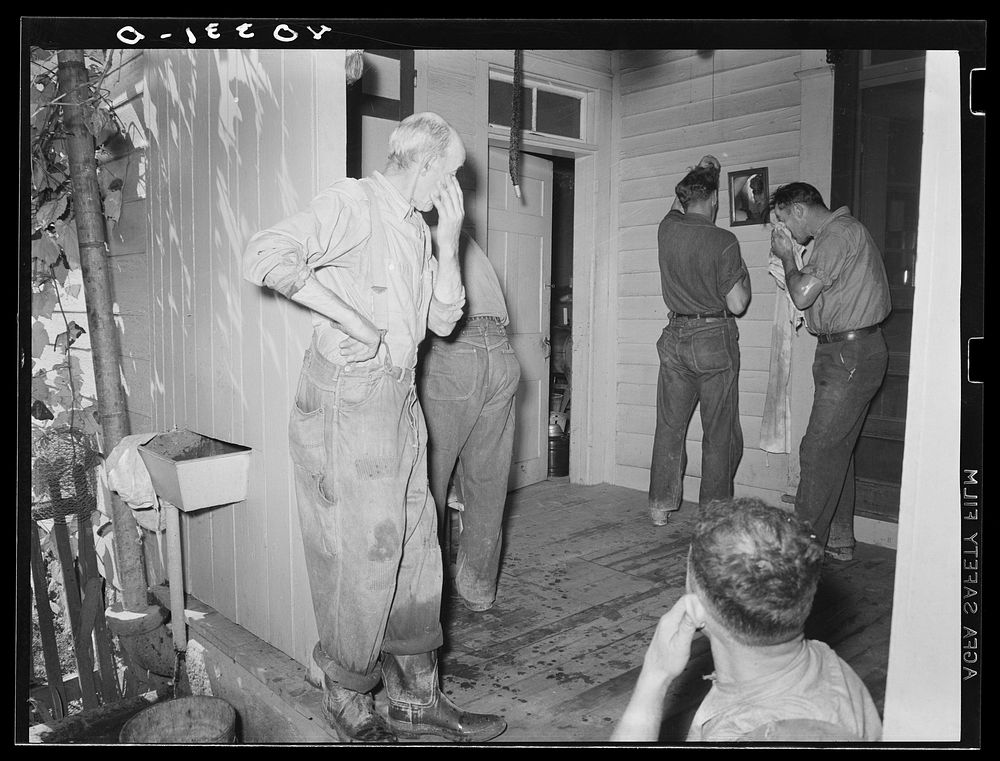 Lancaster County, Pennsylvania. Men who have come to help Royer fill his silo washing up on the back porch of the Enos Royer…