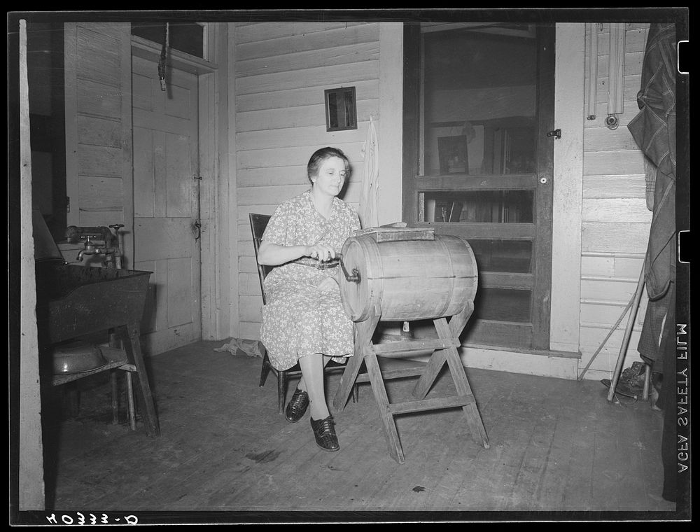 Lancaster County, Pennsylvania. Mrs. Royer churning butter on the back porch of the Enos Royer farm. Sourced from the…