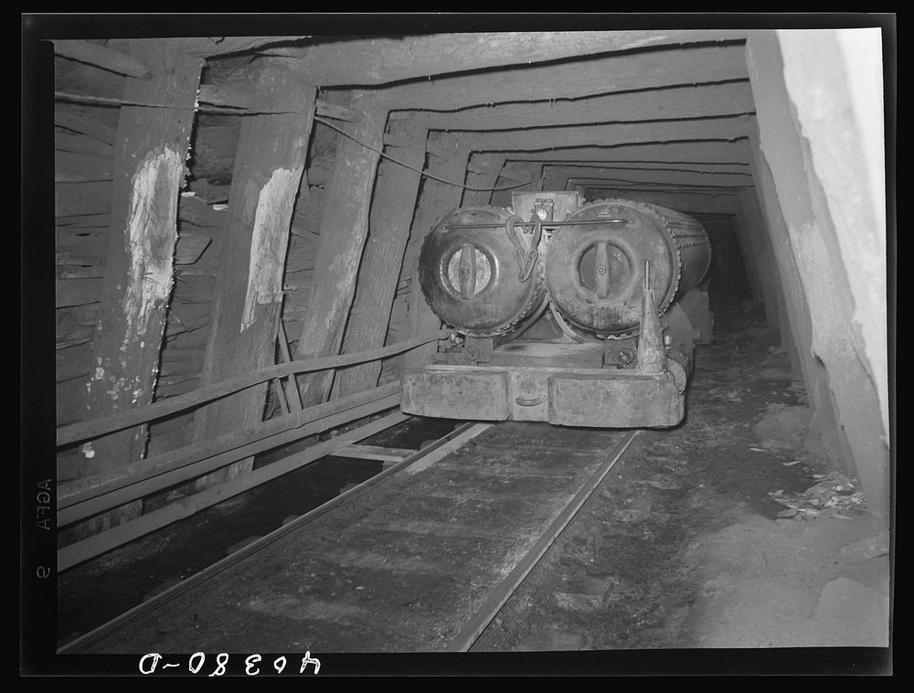Shenandoah (vicinity), Pennsylvania. A compressed air engine approaching with a train of cars in the Maple Hill mine. The…