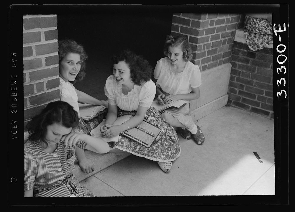 Randolph Henry High School. Keysville, Virginia. Girls talking and studying at the school entrance. Sourced from the Library…