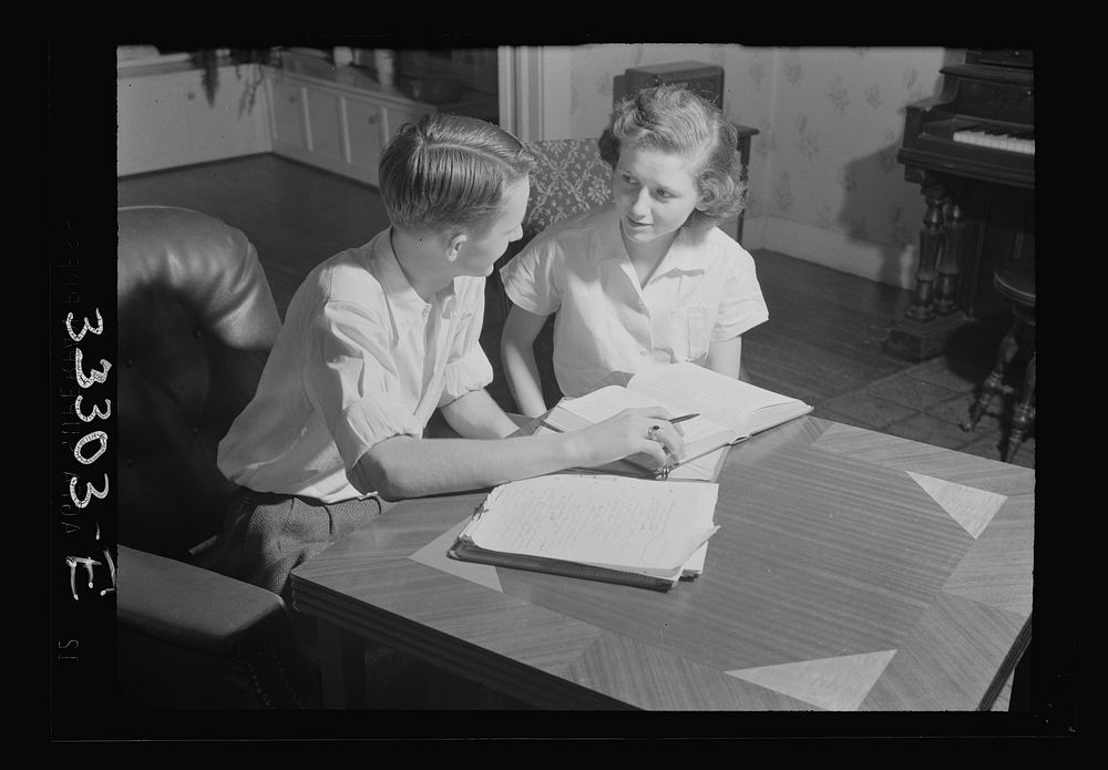 Keysville, Virginia. One of the teachers in the school helping her brother, a pupil, with his studies. He and his brother…