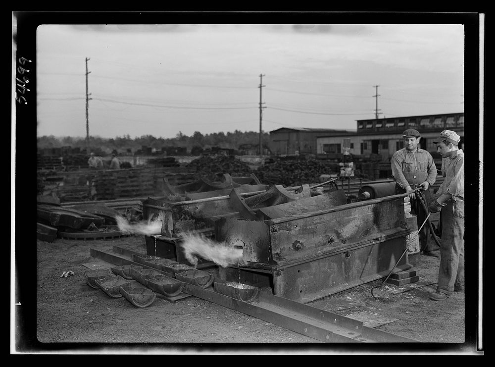 Boston and Maine railroad shops at Billerica, Massachusetts. Open air furnaces melting the lead from the huge locomotive…