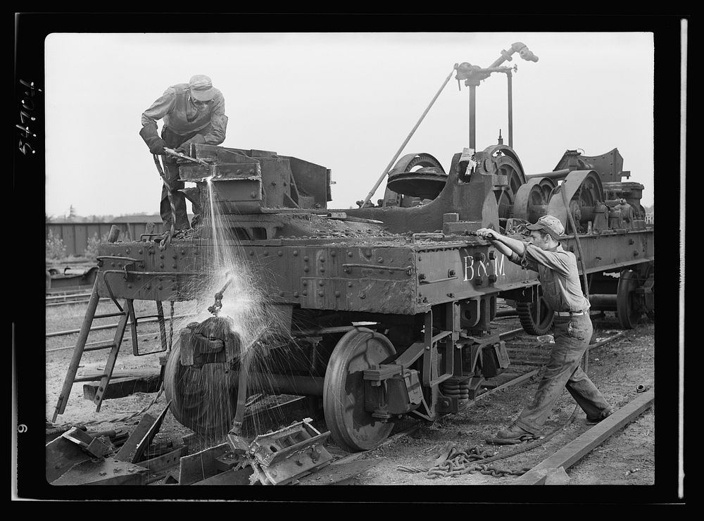 Boston and Maine railroad shops at Billerica, Massachusetts. Dismantling a railroad wrecking crane. Sourced from the Library…