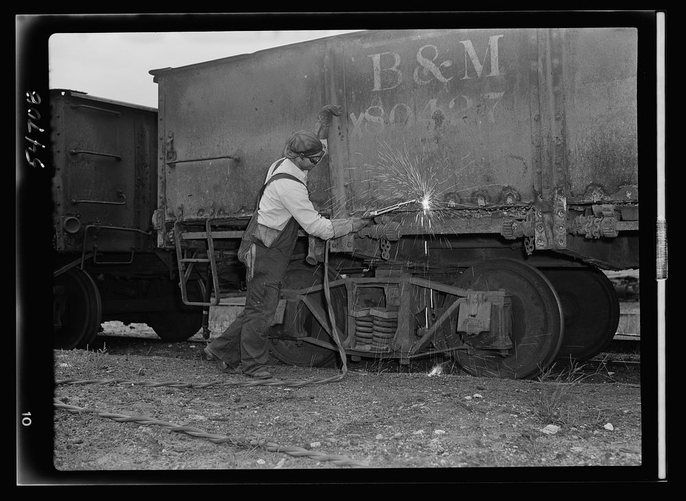 Boston and Maine railroad shops at Billerica, Massachusetts. Welder using special  flame to melt only head of rivet so it…