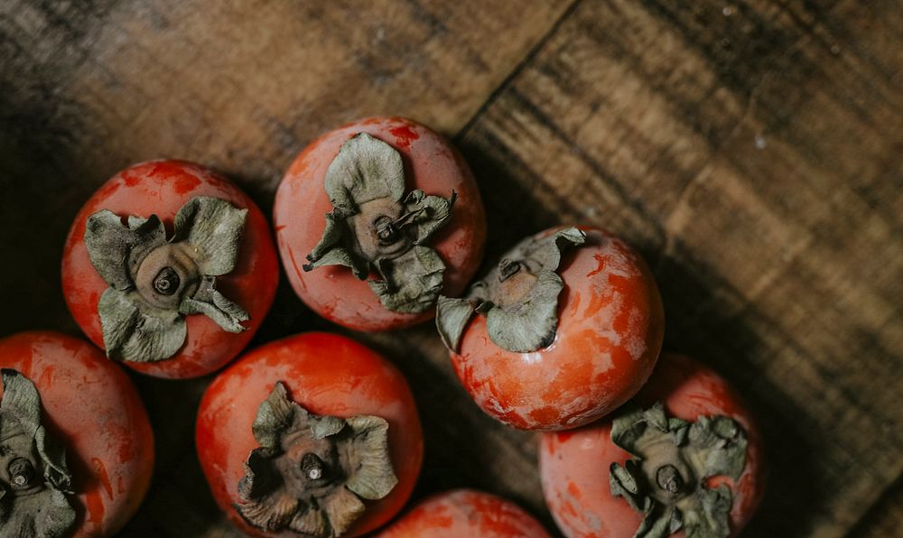 Fresh ripe persimmons on a wooden table