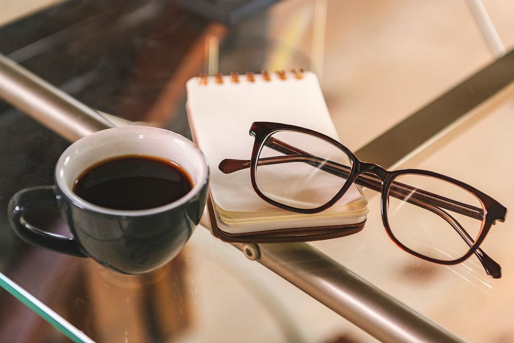 Glasses and a coffee cup on a glass table