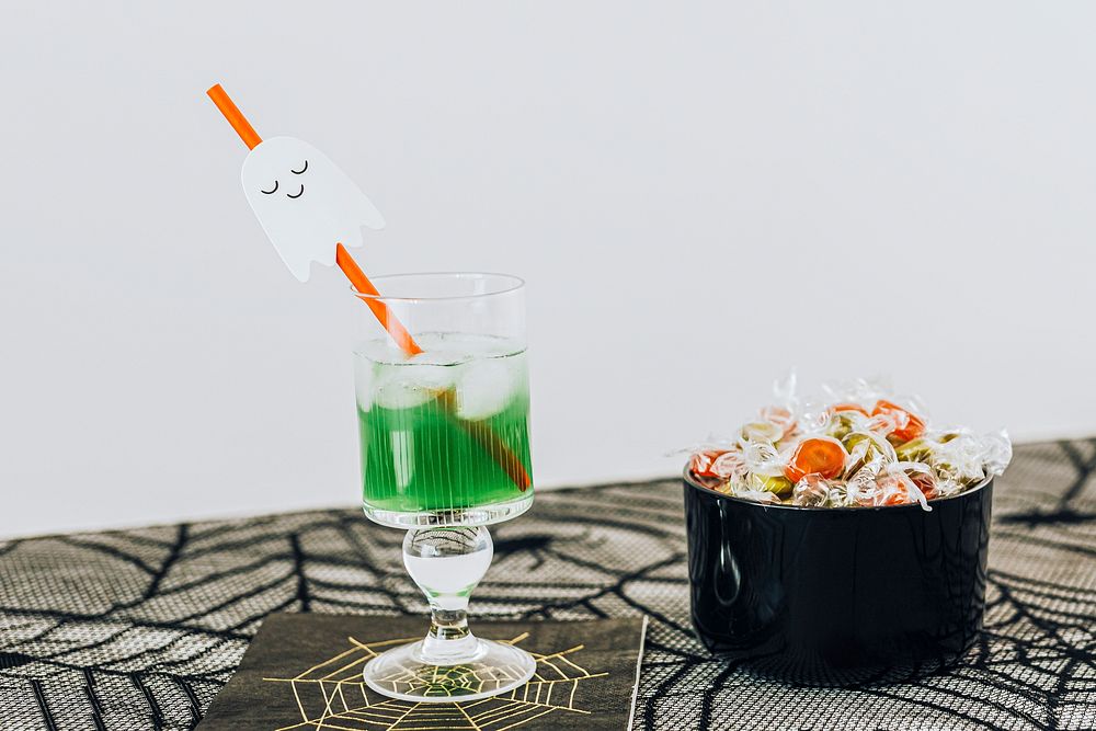 Halloween party with a drink and a bowl of candies on the table 