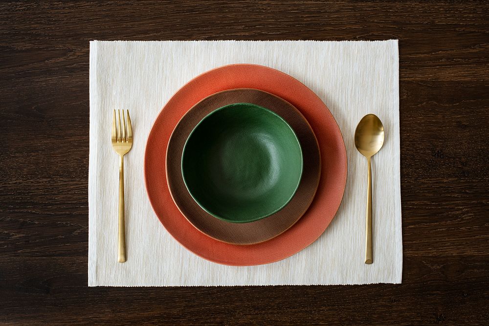 Colorful dinnerware set on a wooden table aerial view
