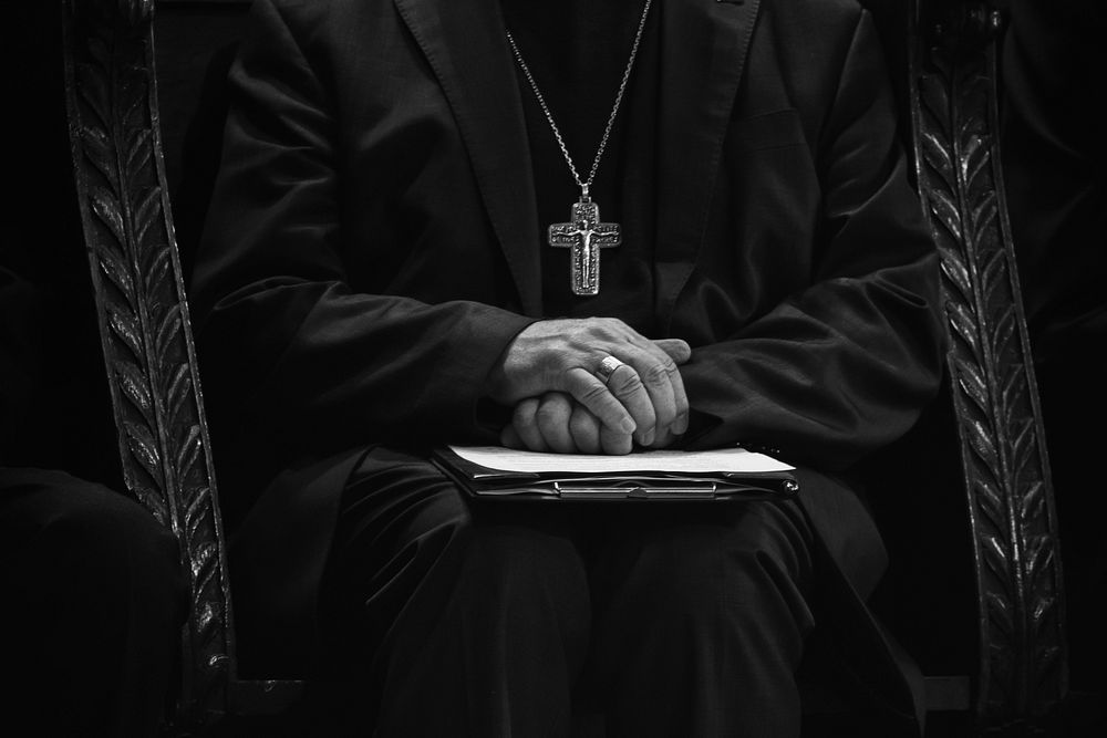Free close up hands of a sitting priest image, public domain CC0 photo.