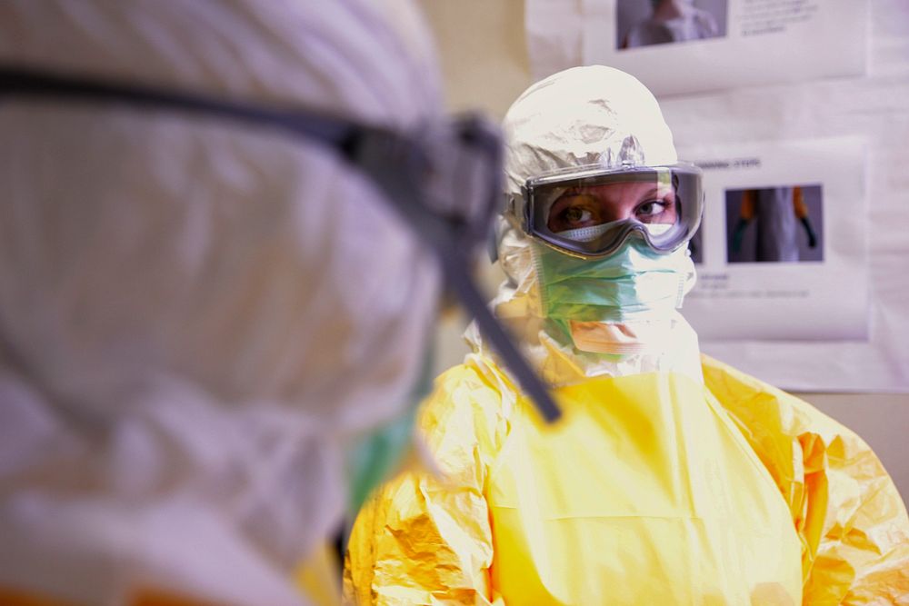 Healthcare workers donning a pair of protective goggles and protective equipment. Original image sourced from US Government…