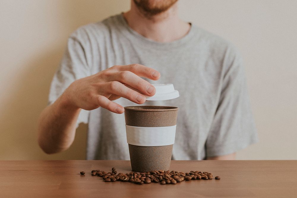 Man opening a reusable coffee cup