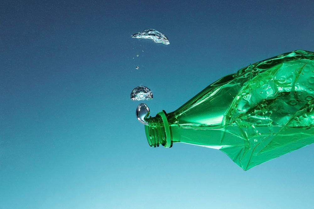 Green plastic bottle polluting the ocean