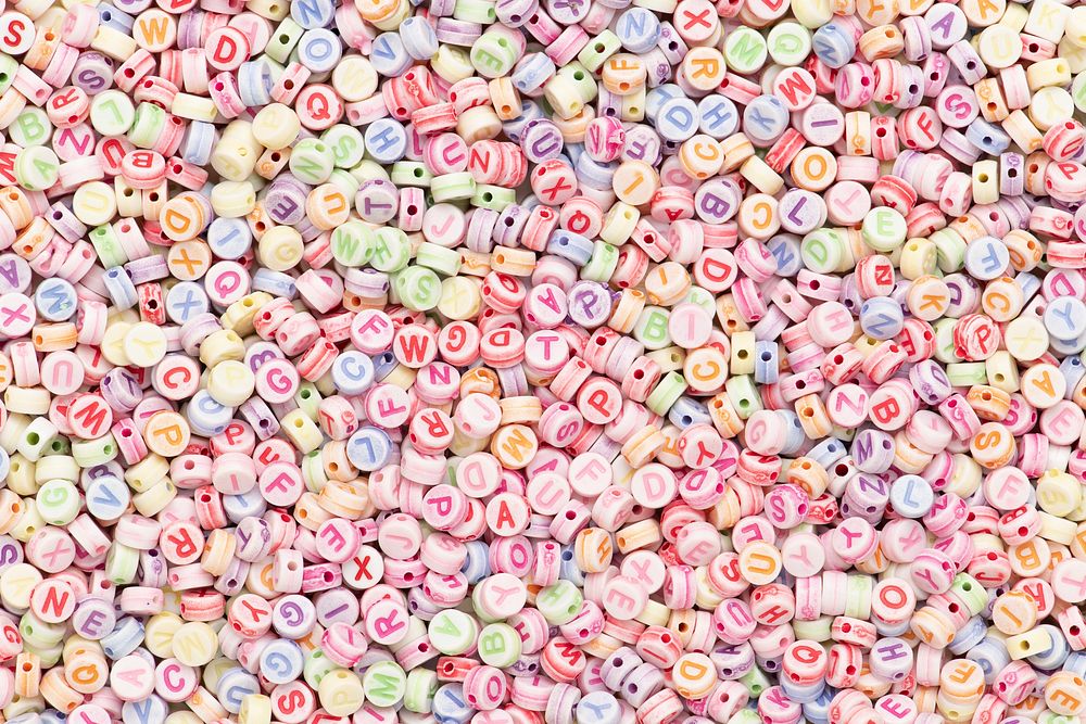 Pastel English letter alphabet beads background