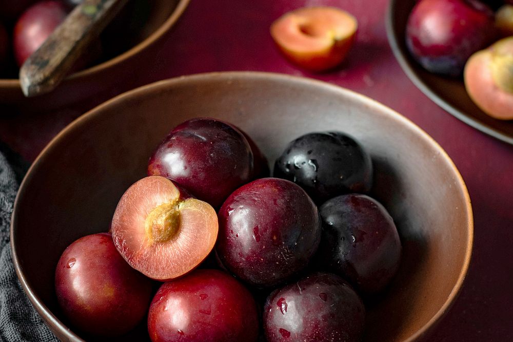 Red plums in a bowl summer food flatlay