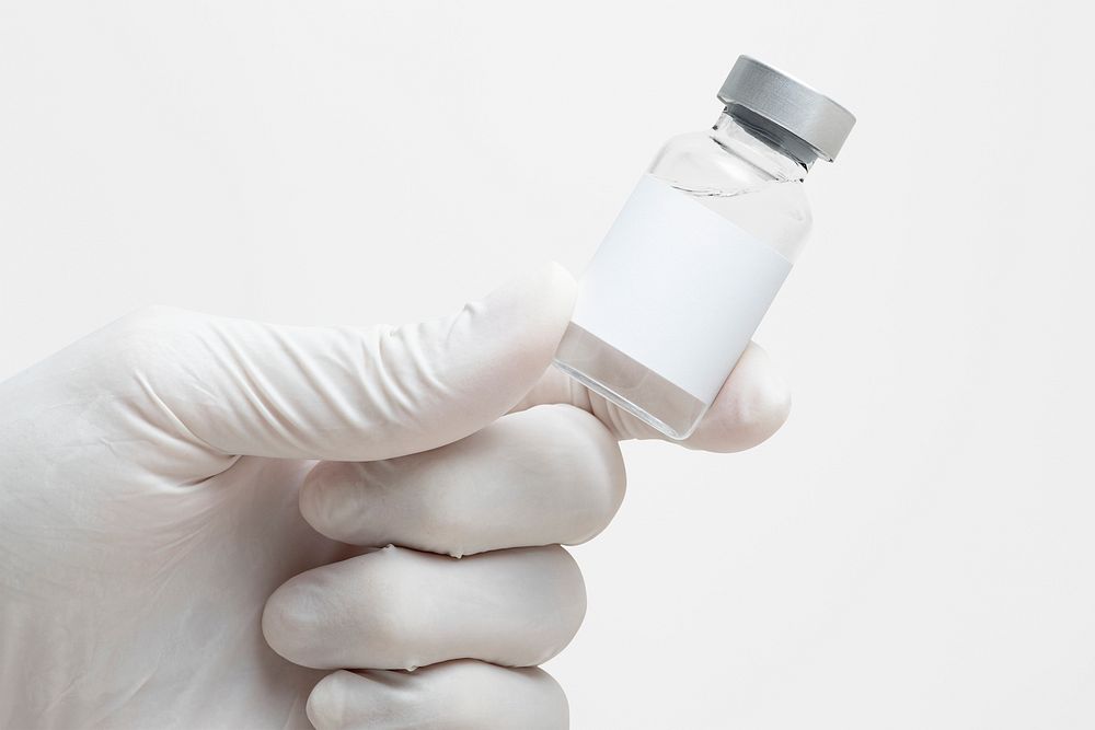 Scientist's hand holding medicine glass vial with blank white label