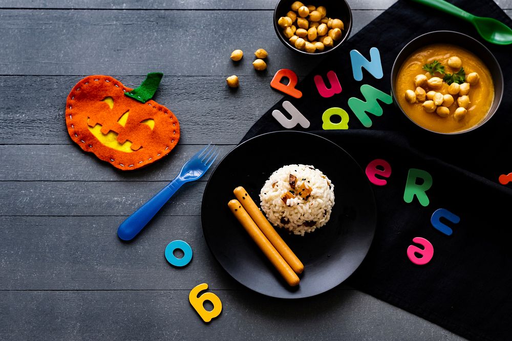 Kids Halloween party food with pumpkin risotto and frankfurters, background wallpaper