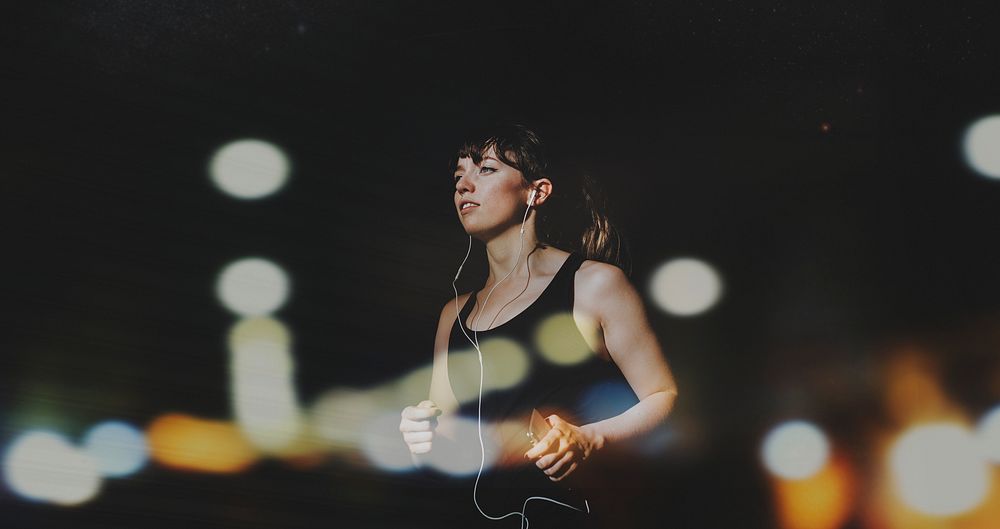 Sporty woman jogging in a dark alley