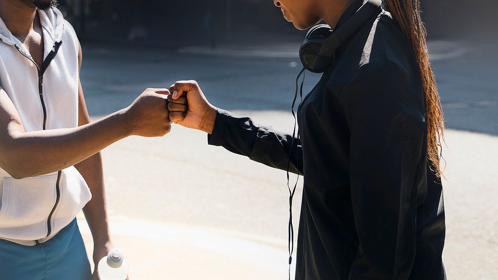 Friends fist bumping each other on the streets