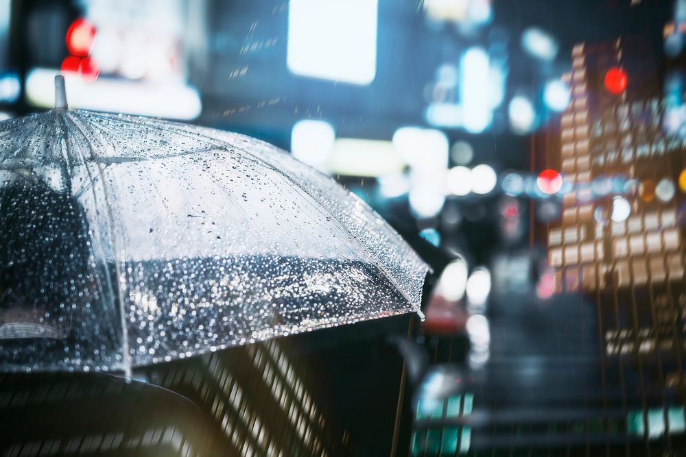 Businessman with umbrella in rainy city