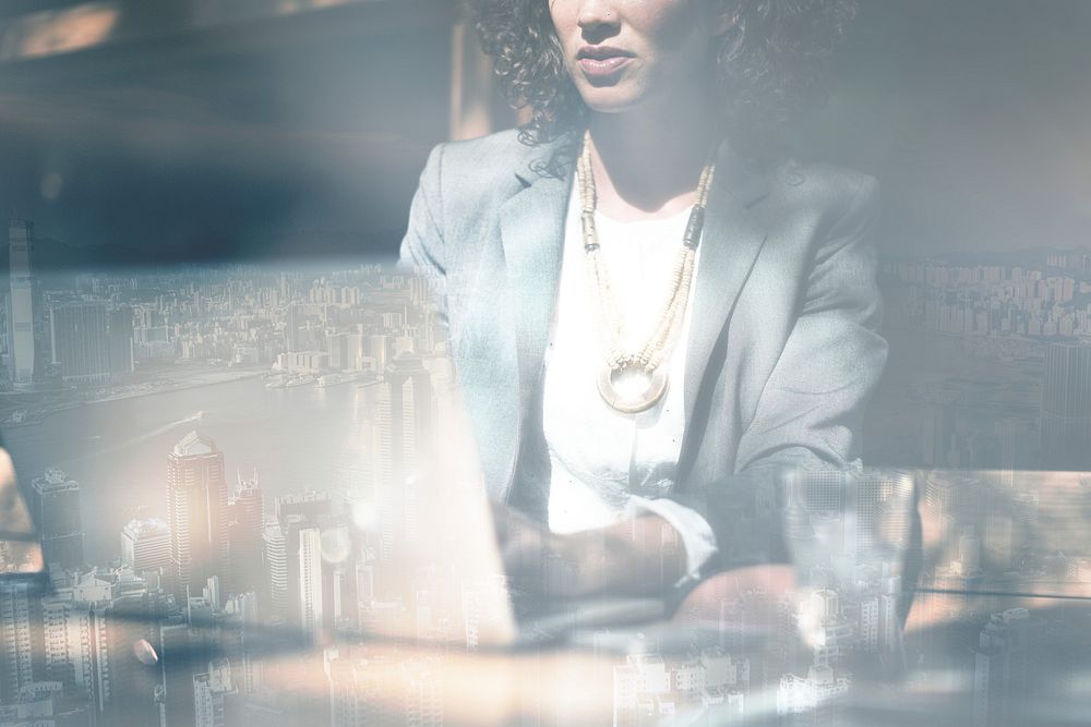 Businesswoman working on a laptop city background